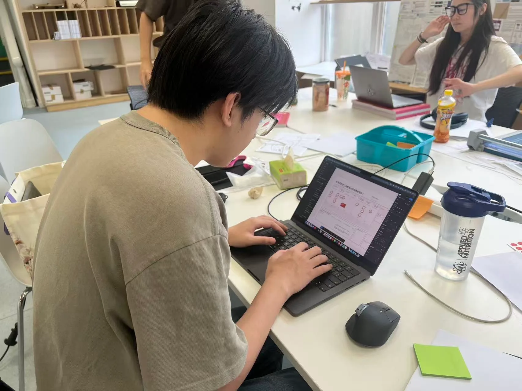 A participant at a laptop working on the Trace the Line process map during the first in-person session