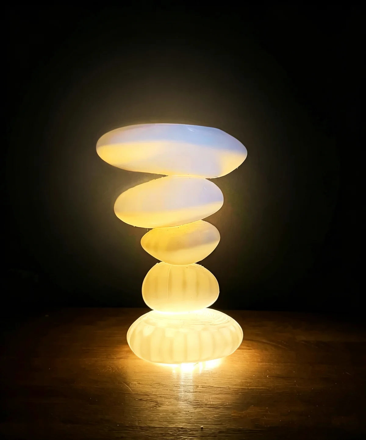 The team's prototype: a stack of translucent 3D-printed stones lit from inside, glowing warm on a dark table